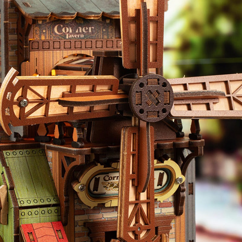 A wooden windmill turns at the side of the tavern.