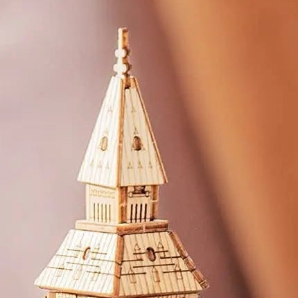 A pointed spire above layered, engraved roof panels.