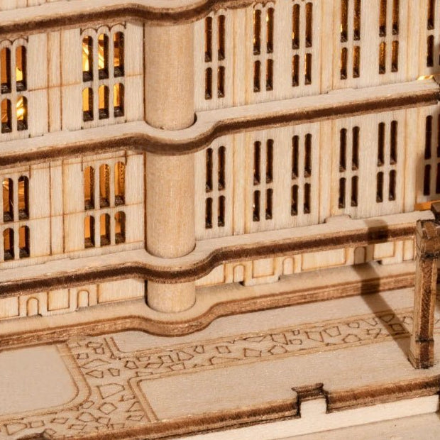 Tall window openings reveal warm light within the lower wing.