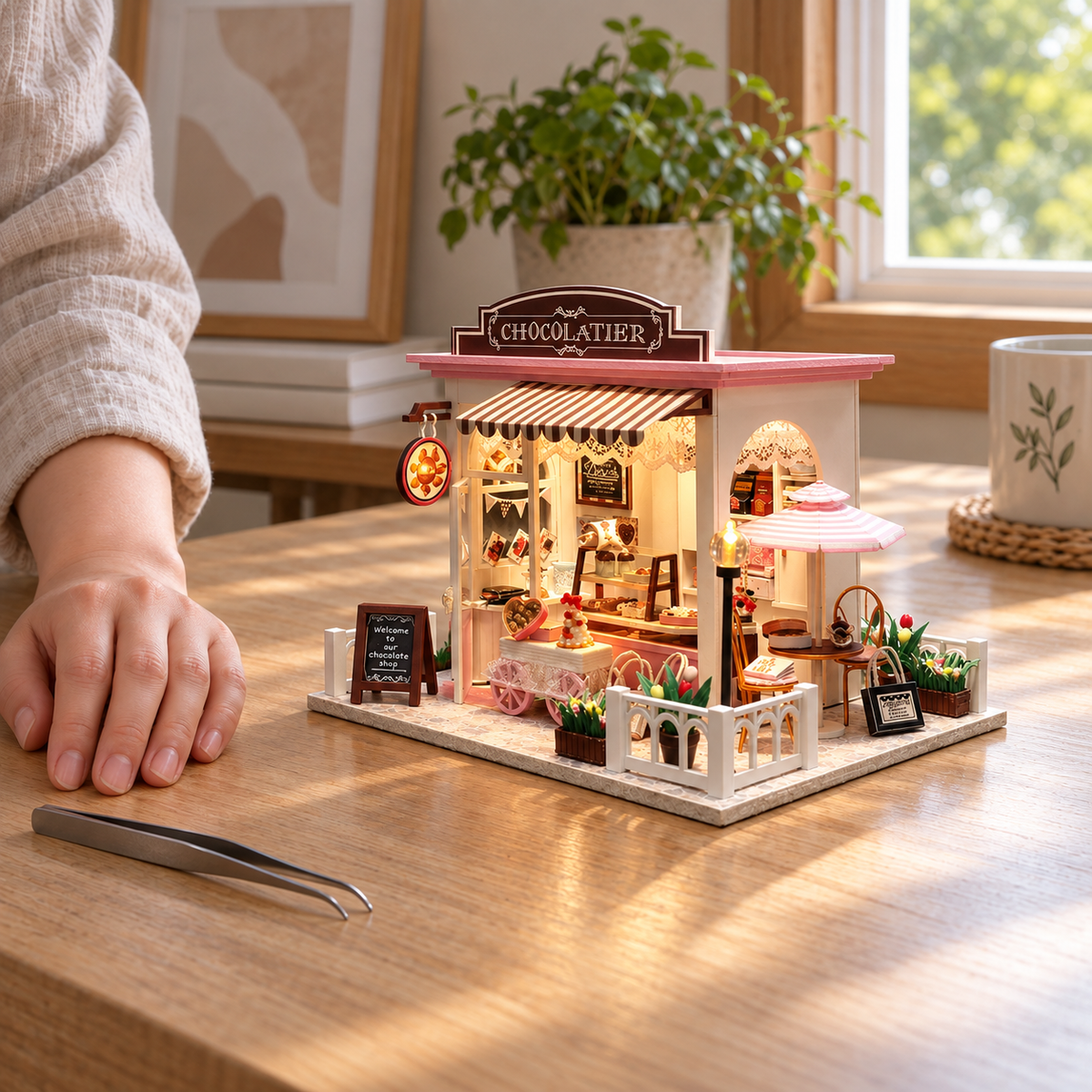 The completed Cocoa's Fantastic Ideas chocolate shop beside a resting hand on a craft table