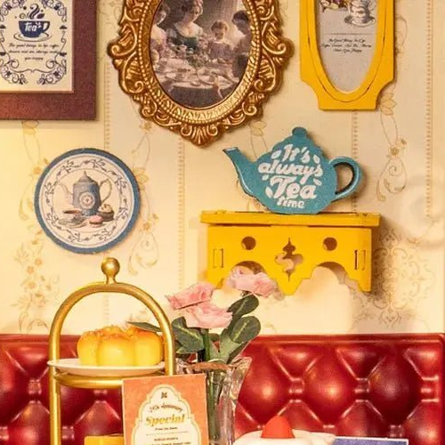 Framed pictures, a decorative plate and a teapot-shaped sign.