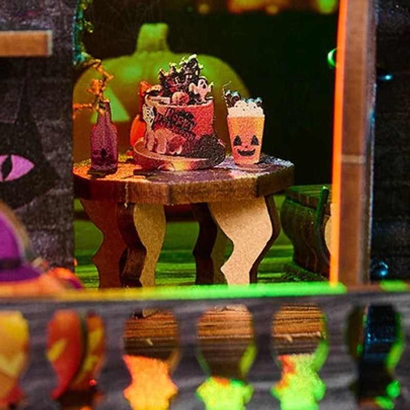 A tiny party table is set with cake and Halloween treats.