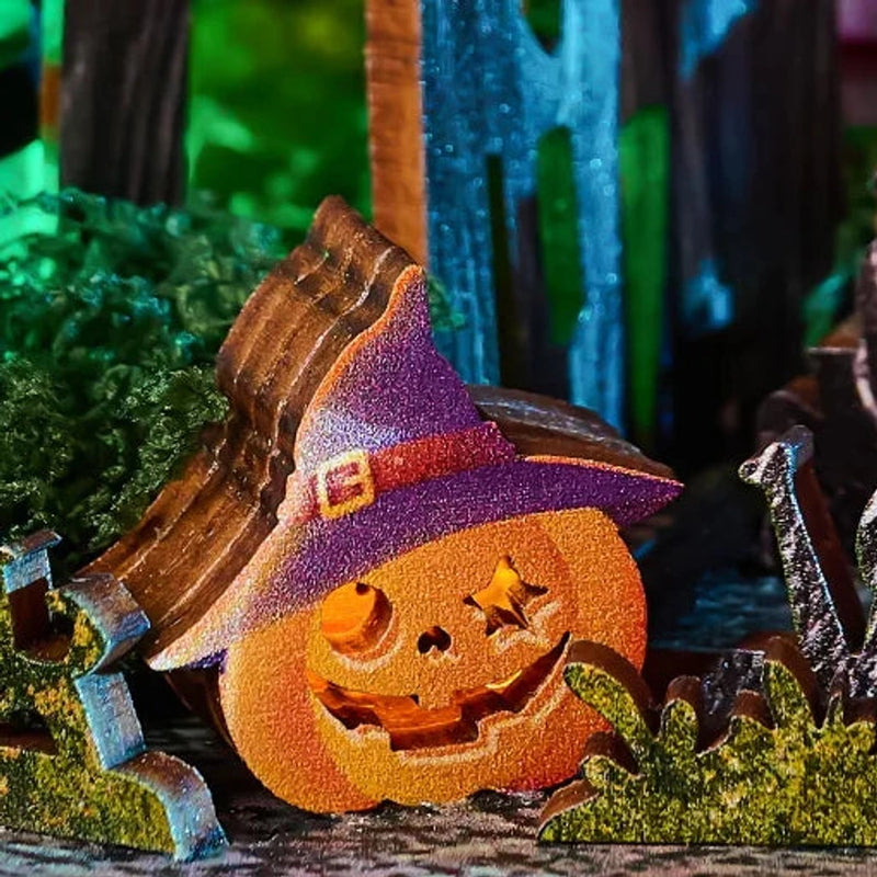 A grinning pumpkin wears a purple witch’s hat by the graveyard.