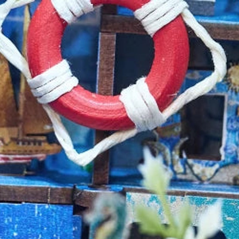 A tiny lifebuoy among sailboats and seaside keepsakes.