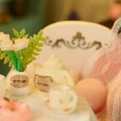 A flower vase beside the miniature tea set