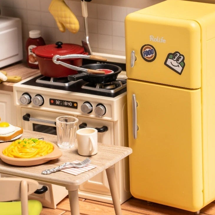 A rounded yellow fridge beside the stove and little dining table.