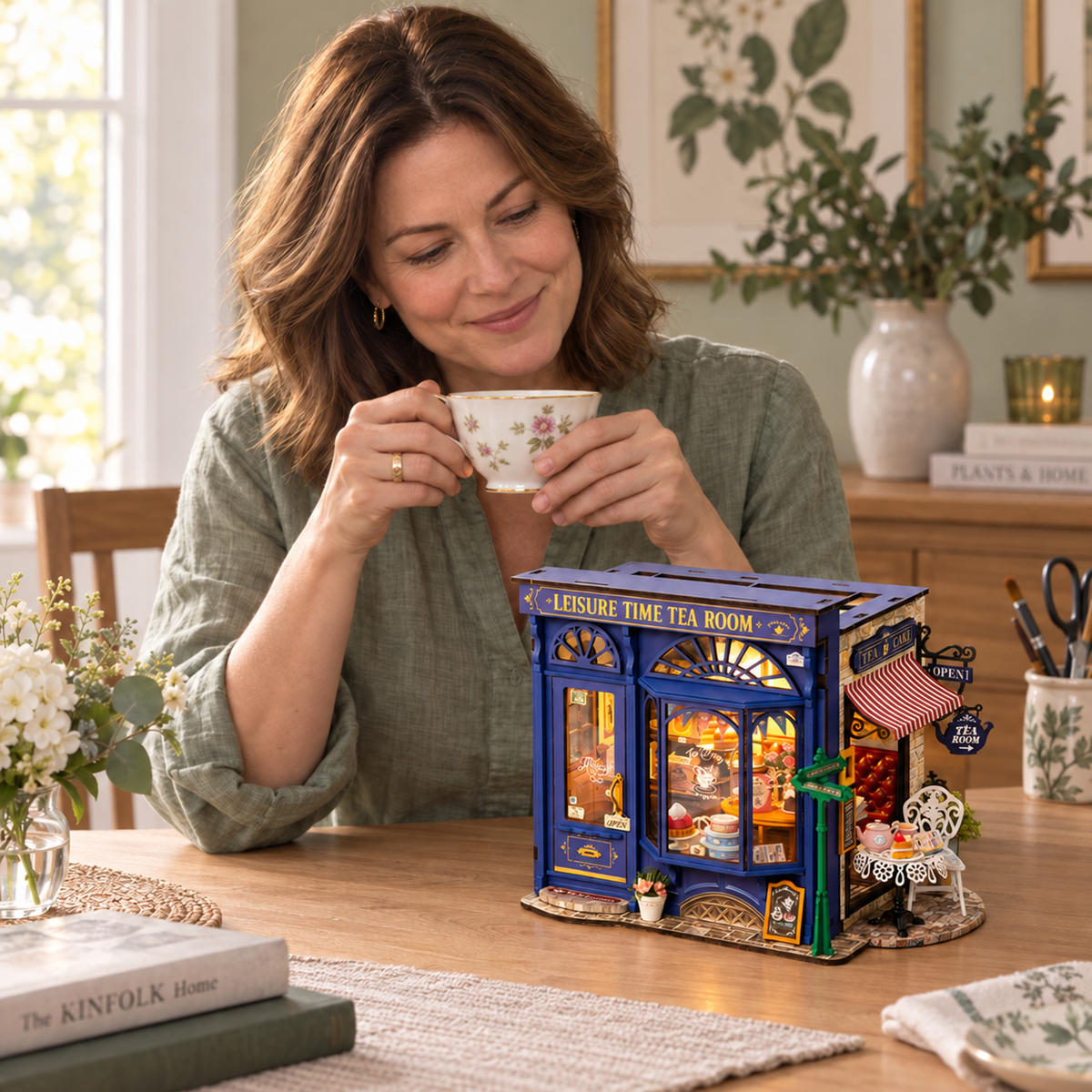 Lifestyle illustration of a maker enjoying tea beside her completed miniature tea room.