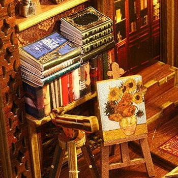 A miniature telescope beside a sunflower painting and stacked books.