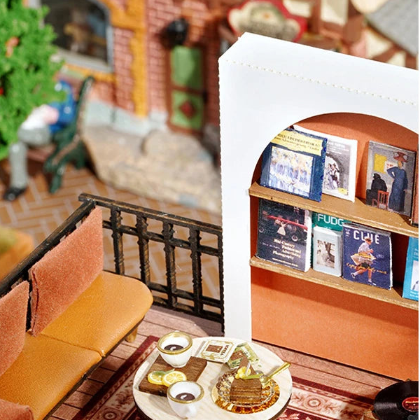 An orange-backed arched bookshelf beside a matching café seat.