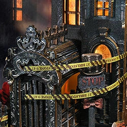 Yellow caution tape crosses an ornate gate beneath dark façades.