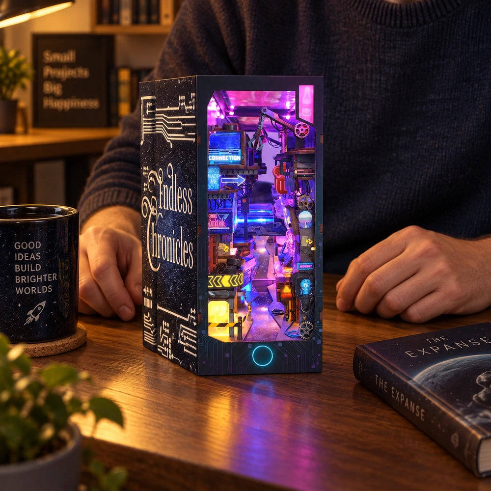 A maker admires the completed Endless Dimensions miniature at a home desk, with its colourful lights on