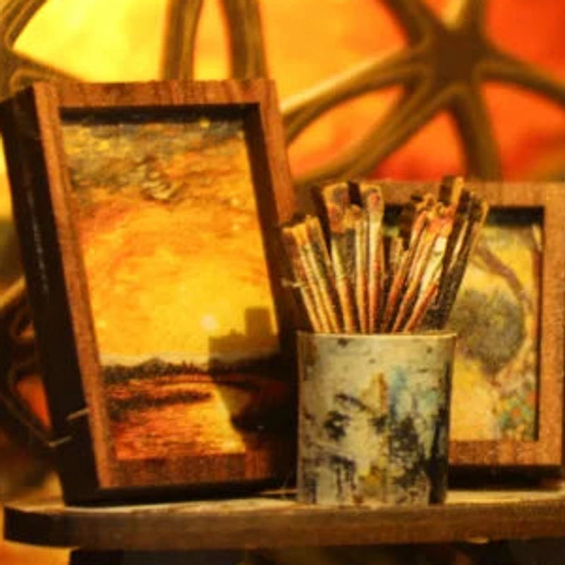Brushes and framed paintings by the window