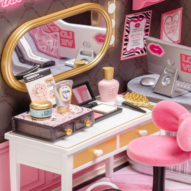 A gold-framed mirror above the little vanity