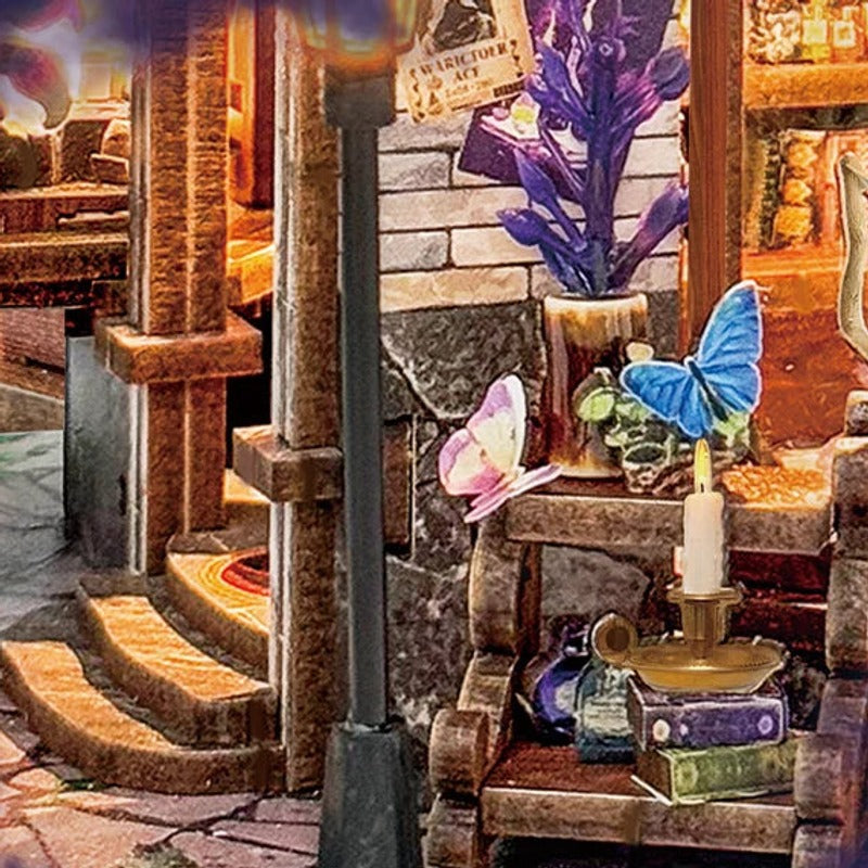 A butterfly rests beside the tiny candle and books.