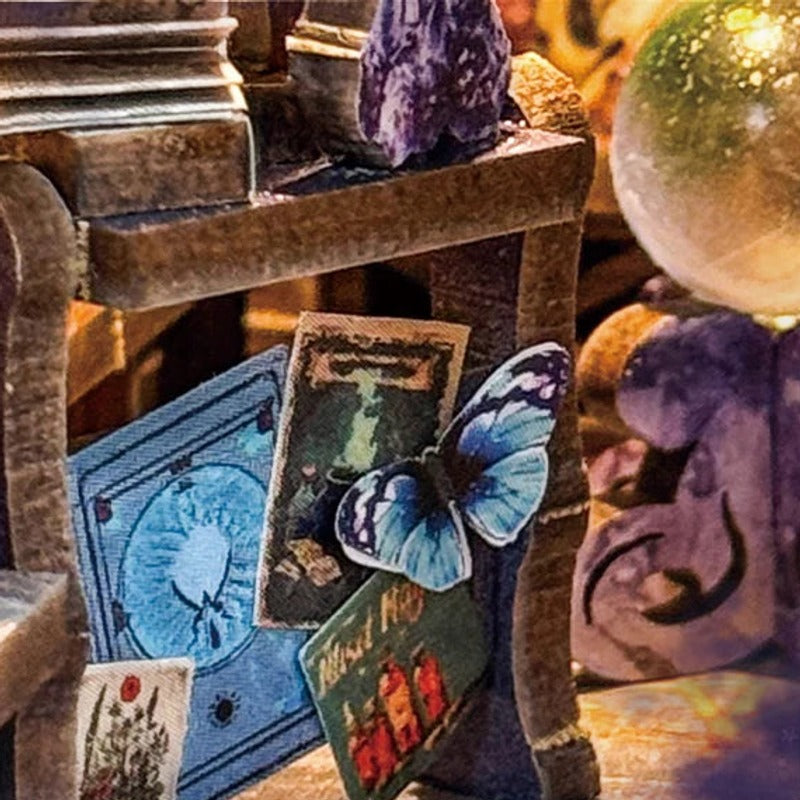 Spell books, crystals and a butterfly in miniature.